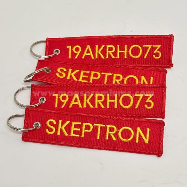 Branded woven keychain with intricate embroidery, designed for corporate giveaways, event promotions, and aviation-style key tags