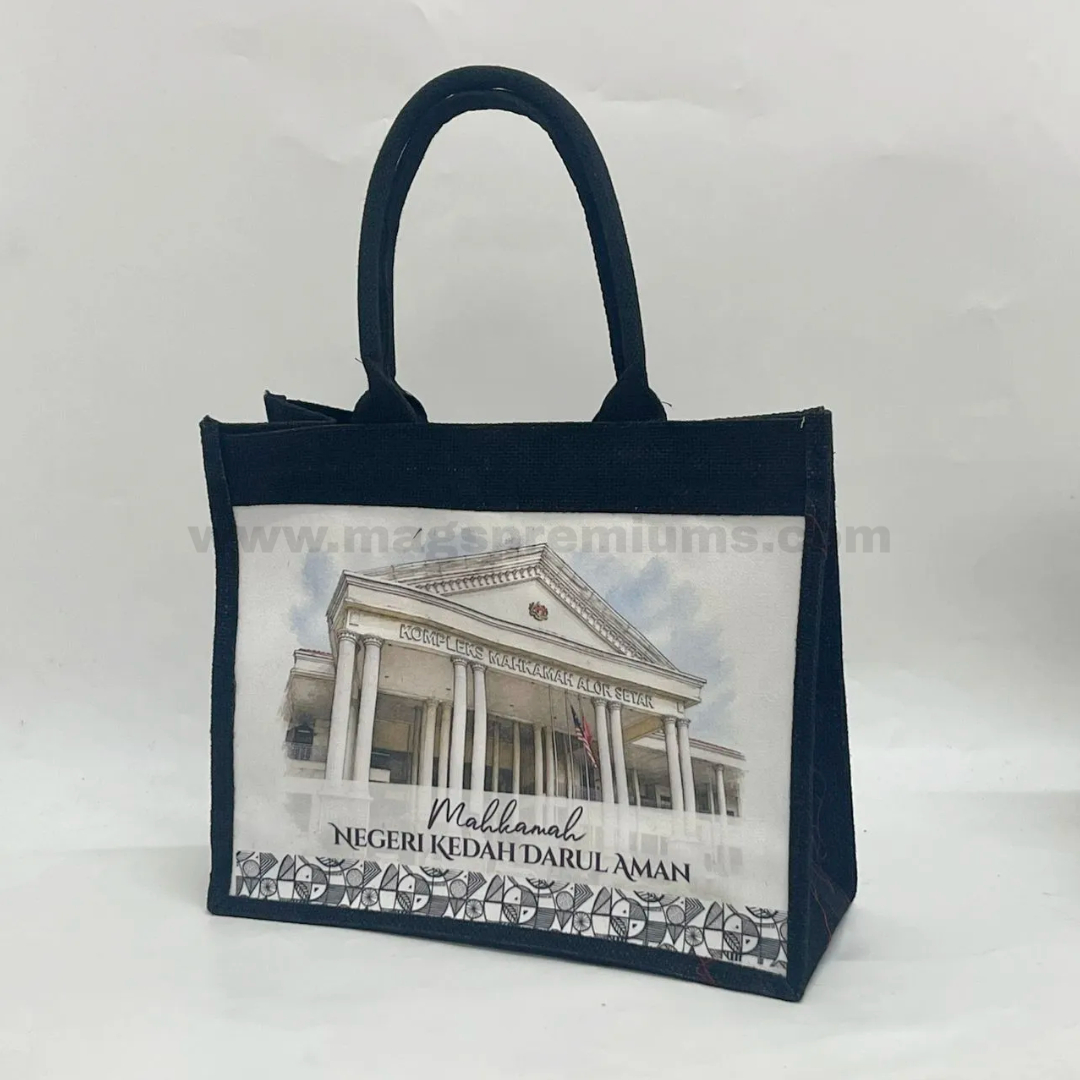 Black laminated jute bag with matching black handles and custom full-color front panel printing featuring Mahkamah Negeri Kedah Darul Aman building, ideal for corporate gifts, event merchandise, and reusable promotional packaging.