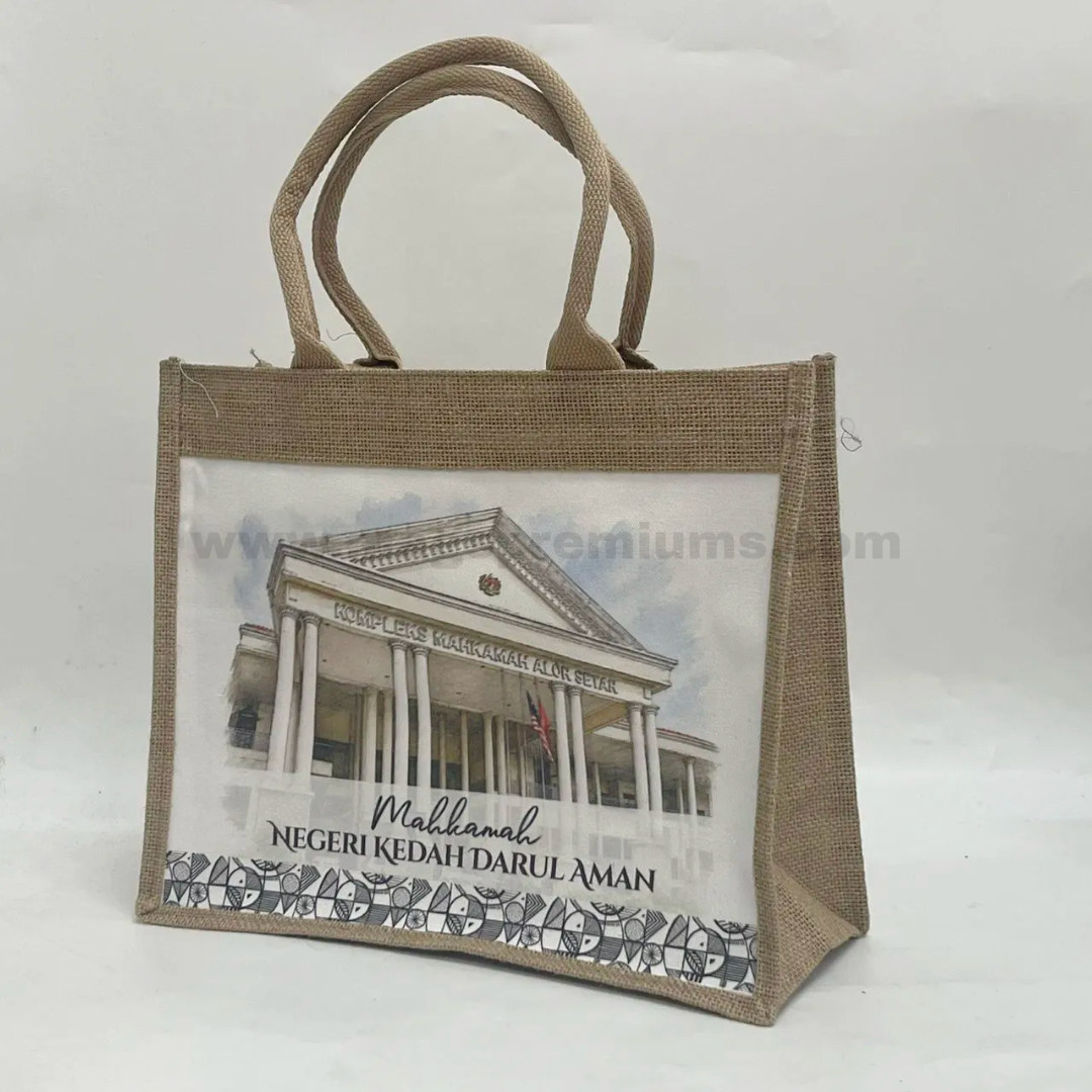 Natural colored jute bag with sturdy handles and custom full-color front panel printing featuring Mahkamah Negeri Kedah Darul Aman building, suitable for corporate gifts, events, and eco-friendly promotional packaging.