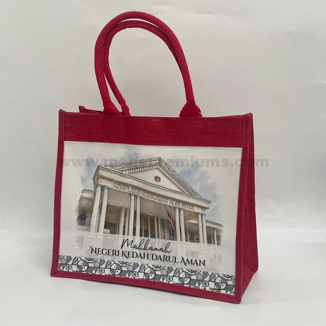 Red promotional jute bag with matching red handles and custom full-color front panel printing featuring Mahkamah Negeri Kedah Darul Aman building, suitable for corporate gifts, promotional merchandise, events, and eco-friendly packaging.